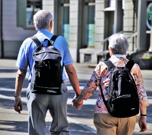 aging couple walking down street